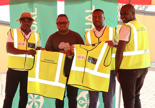 Men belonging to a Namibian neighbourhood watch group hold matching yellow vests. 