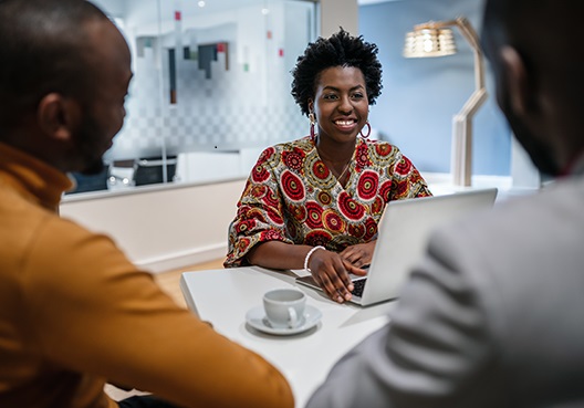 A female Old Mutual employee has a meeting with two customers. 