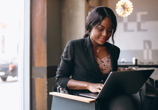 A well dressed, professional woman working on her laptop